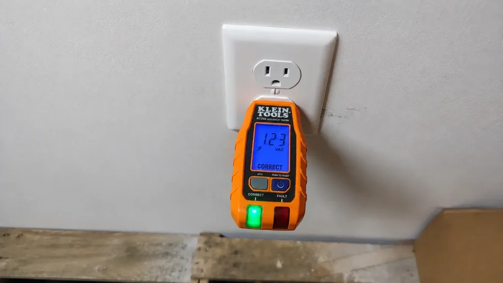 GFCI outlet Electrician testing a standard 120V electrical outlet with a digital receptacle tester during a residential electrical inspection in Miami.