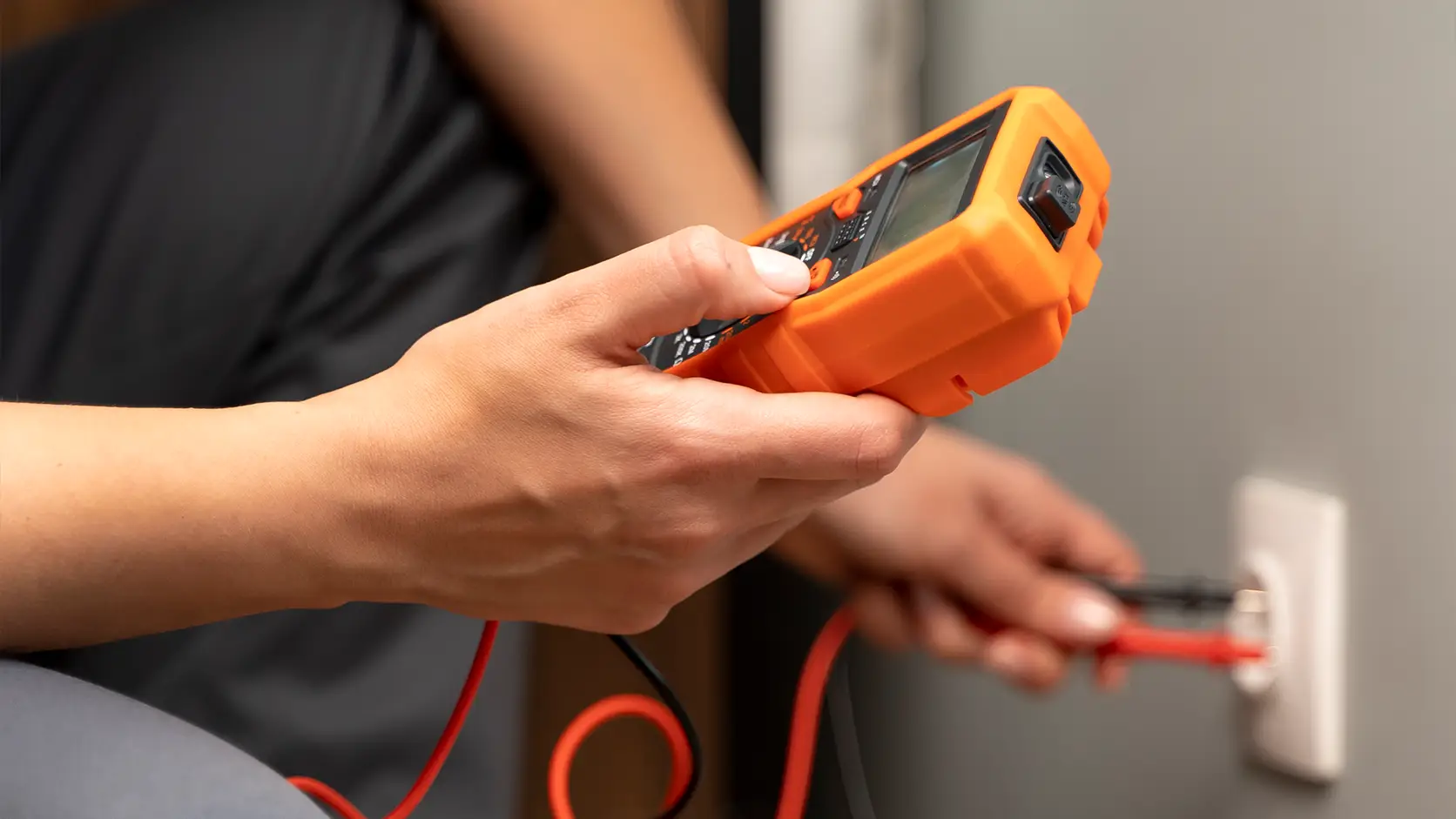 electrical repair 2 Professional electrician using a digital multimeter to test the voltage of a residential electrical outlet.